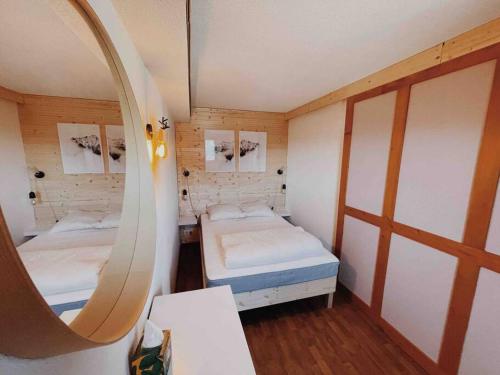 une petite chambre avec deux lits et un miroir dans l'établissement Appartement Puy Saint Vincent 1800, à Puy-Saint-Vincent