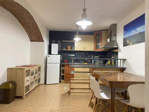 a kitchen with a table and a white refrigerator at Cozy Downtown Garden Apartment: Spacious, Historical & Culinary Delight! in Prague