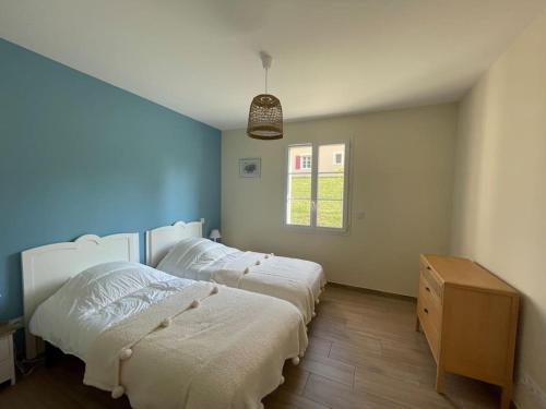 - 2 lits dans une chambre avec un mur bleu dans l'établissement Les Cypres*Maison au calme*Piscine chauffée, à Sarlat-la-Canéda