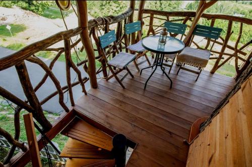 a wooden deck with a table and chairs on it at Dom na strome v Panoráma Parku in Nezbudská Lúčka