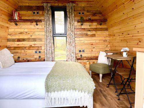 a bedroom with a bed in a log cabin at Willow Pod in Great Ayton