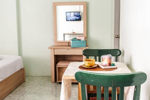 a room with a table and two green chairs at Tower Resident in the Heart of Bangkok Shopping Center in Makkasan