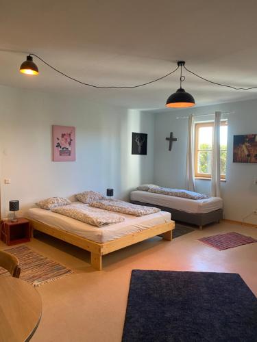 two beds in a room with a cross on the wall at Wolfis Appartement in Neusiedl an der Zaya