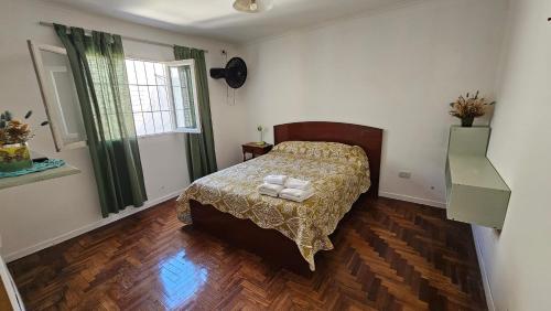 Schlafzimmer mit einem Bett und Holzboden in der Unterkunft Casa San Carlos in Rosario