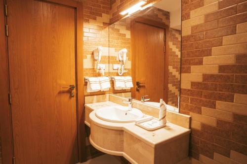 a bathroom with a sink and a mirror at AYA Addis Hotel in Addis Ababa