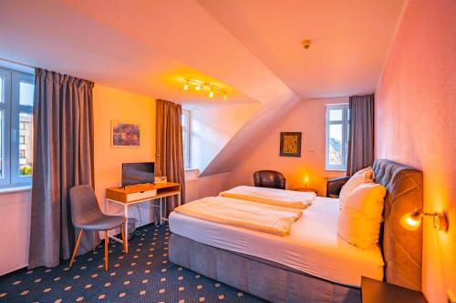 ein Hotelzimmer mit einem Bett und einem Schreibtisch in der Unterkunft Hotel Starke in Brilon