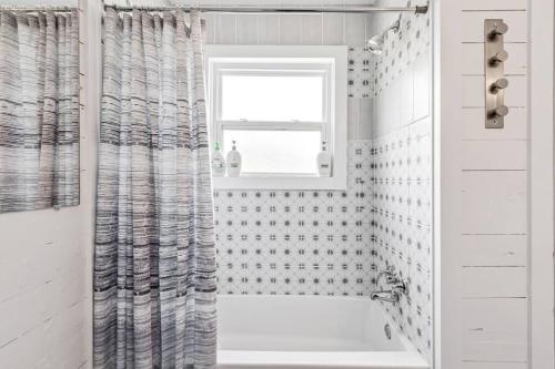 a white bathroom with a shower curtain and a window at Bungalow Bliss - Large Backyard & Fire Pit in McGregor