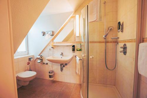 ein Bad mit einem Waschbecken, einem WC und einer Dusche in der Unterkunft Hotel Starke in Brilon