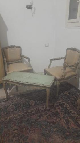 Duas cadeiras e uma mesa de centro num quarto em مزرعة الدكتور محمد رجب em Alexandria