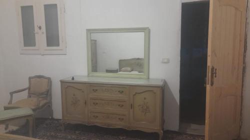 einen Spiegel auf der Kommode in einem Zimmer in der Unterkunft مزرعة الدكتور محمد رجب in Alexandria