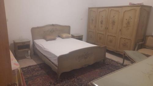 a bedroom with a bed and two wooden cabinets at مزرعة الدكتور محمد رجب in Alexandria