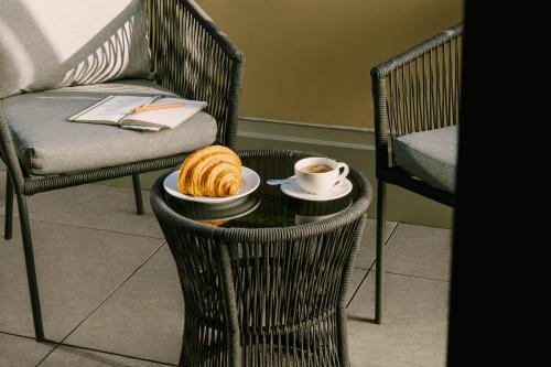 溫哥華的住宿－Sonder at Revival，一张桌子,上面放着一杯咖啡和一盘羊角面包