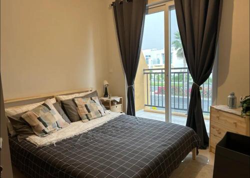 1 dormitorio con cama y ventana grande en Villa 417 en Dubái