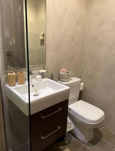 a bathroom with a white sink and a toilet at Villa 417 in Dubai