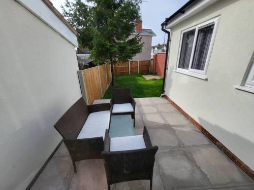 un patio con 2 bancos, mesa y sillas en Enquire now - 3 bed house - Up to 35% off - Contractors and Families, en Coventry