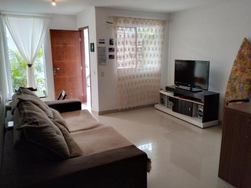 a living room with a couch and a flat screen tv at Casa privativa no norte da ilha in Florianópolis