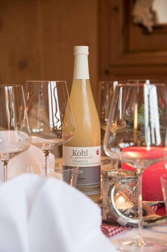 a bottle of wine and two wine glasses on a table at Hotel Die Arlbergerin - Design & Tiroler Gemütlichkeit in Sankt Anton am Arlberg