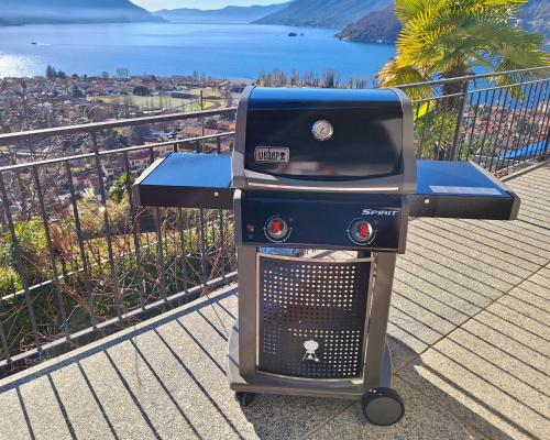 a bbq grill sitting on top of a balcony at Sole & Lago-Lake in Maccagno con Pino e Veddasca