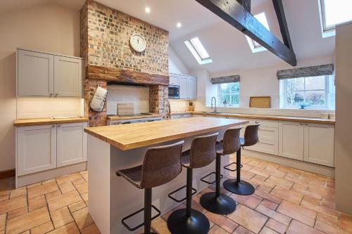 a kitchen with a large island with bar stools at Host & Stay - The Orchard in Cramlington