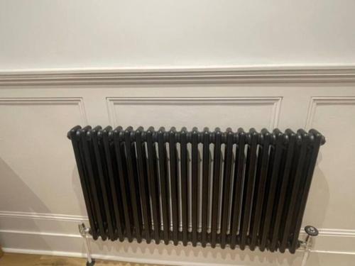 a black radiator against a white wall at Homely garden apartment, newly refurbished - sleeps four in Brighton & Hove
