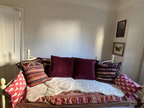 a bed with a bunch of pillows on it at Homely garden apartment, newly refurbished - sleeps four in Brighton & Hove