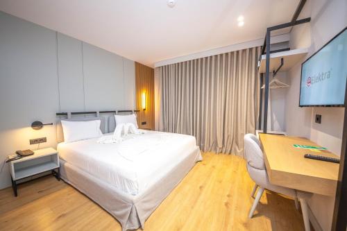 a hotel room with a bed and a desk and a computer at Hotel Sole Mare in Ksamil