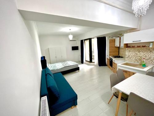 um pequeno apartamento com um sofá azul e uma cozinha em Solid Residence Sea View em Mamaia