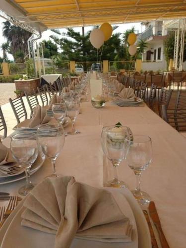a long table with wine glasses and a napkin on it at Hotel Mariagrazia in Calopezzati