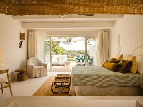 a bedroom with a bed and a large window at Morvedra Nou Luxury Boutique Hotel - Adults Only in Ciutadella