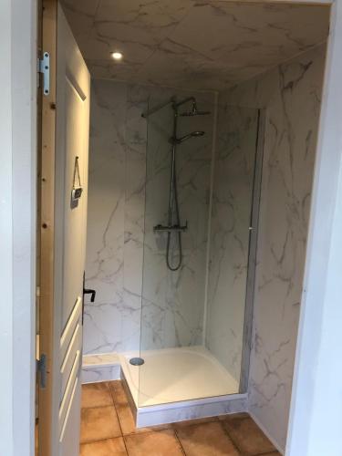 a bathroom with a shower with a glass door at La Dernière Étape in Port-Launay