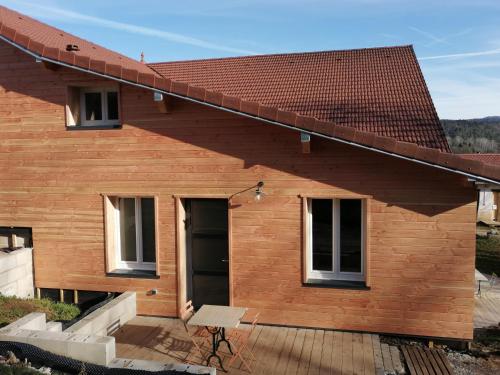 a wooden house with a roof at Studio aux Granges du Vilaret in Clairvaux-les-Lacs