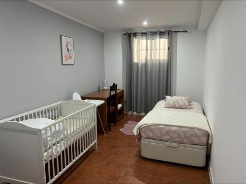um quarto de bebé com um berço e uma cómoda em Gouveia Family Escape em Machico