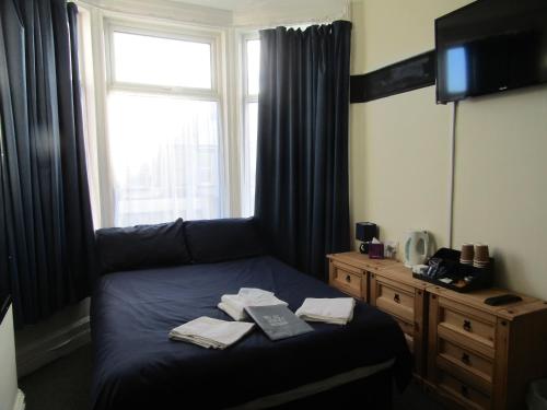 a bedroom with a bed with a window and a television at No12 Guesthouse South Shore Blackpool in Blackpool
