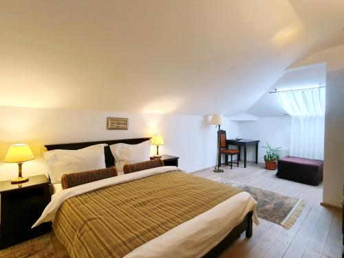 a bedroom with a large bed and a desk at Vila Leonida - RESORT LEONIDA in Buşteni
