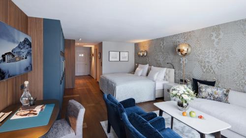 a hotel room with a bed and a couch at Hotel Zürserhof in Zürs am Arlberg