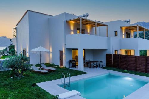 a house with a swimming pool in front of it at Increteblue Suites in Plakias