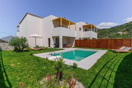 a house with a swimming pool in the yard at Increteblue Suites in Plakias