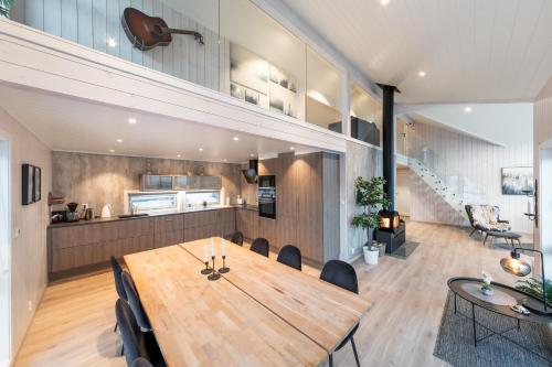 a dining room and kitchen with a wooden table and chairs at Vikran Seaside Lodge in Straumsjøen