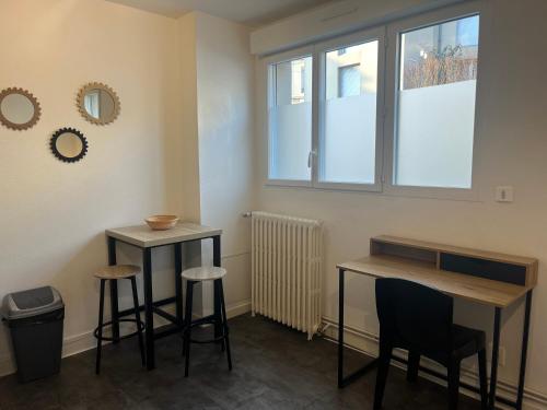 een kamer met 2 krukken, een tafel en een raam bij Le 2 - Grand studio avec coin repas Caen Port in Caen