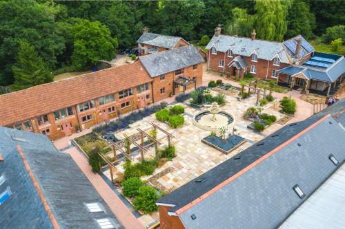 una vista aérea de un gran edificio de ladrillo con un patio en Lime Cottage - Great Houndbeare Farm Holiday Cottages en Aylesbeare