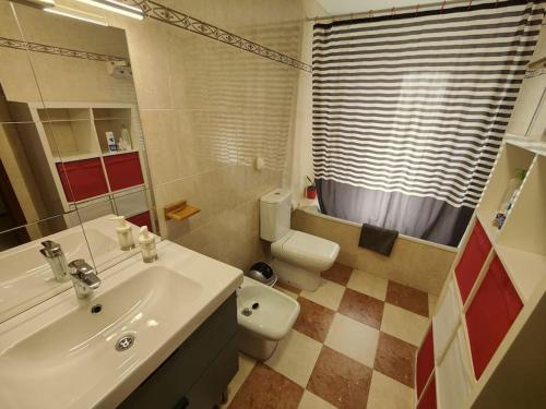 a bathroom with a white sink and a toilet at Tranquilo y Elegante in Cenes de la Vega