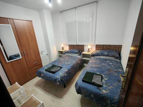 a bedroom with two beds and two lamps and a door at Tranquilo y Elegante in Cenes de la Vega