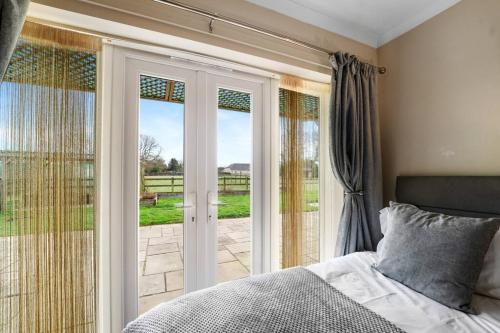 a bedroom with a bed and a sliding glass door at Farm stay outside Canterbury in Stelling