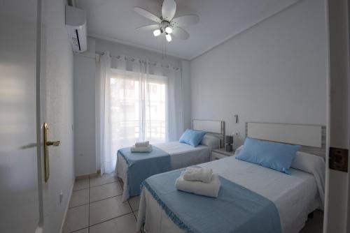 1 Schlafzimmer mit 2 Betten und einem Fenster in der Unterkunft Apartamento arena playa levante in Santa Pola