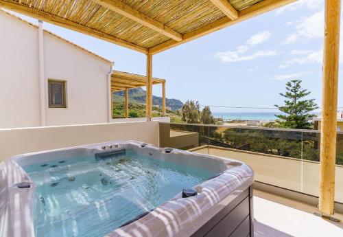 bañera de hidromasaje en el balcón de una casa en Increteblue Suites en Plakiás