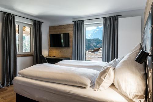 2 Betten in einem Hotelzimmer mit Fenster in der Unterkunft Haus Alpspitzchalet 32 in Garmisch-Partenkirchen