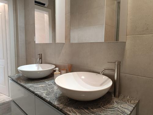 a bathroom with two white sinks on a counter at Villa Bacchus Upper Gate in Ohrid