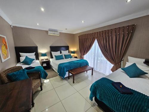 ein Hotelzimmer mit 2 Betten und einem Fenster in der Unterkunft Bettie's Luxury Lodge in Kroonstad