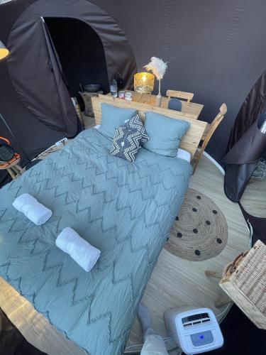 a bedroom with a bed in a tent at La bulle bien belge avec jacuzzi in Lasne