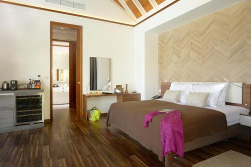 a bedroom with a large bed and a bathroom at Kandolhu Maldives in Himandhoo 